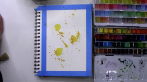Adding yellow paint splatters to art journal