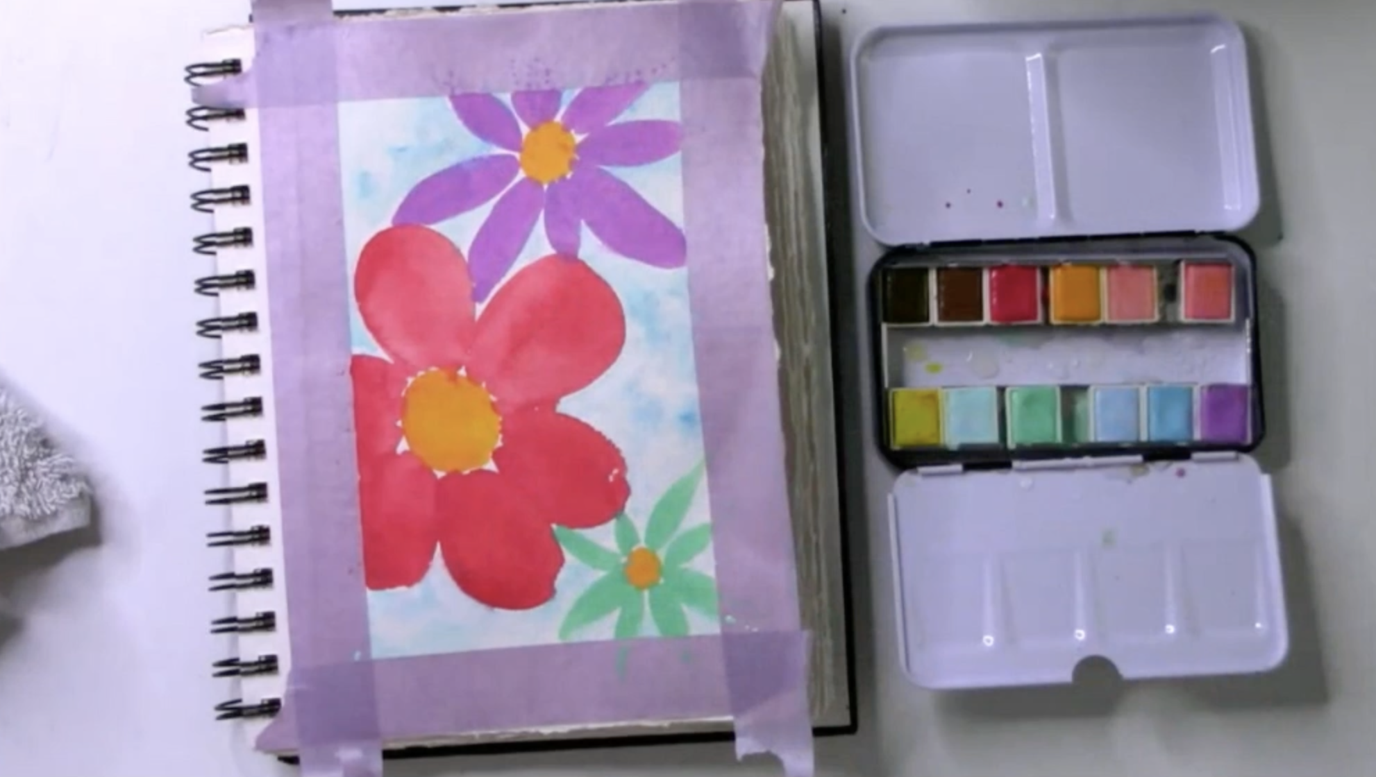 painting watercolor flowers in an art journal