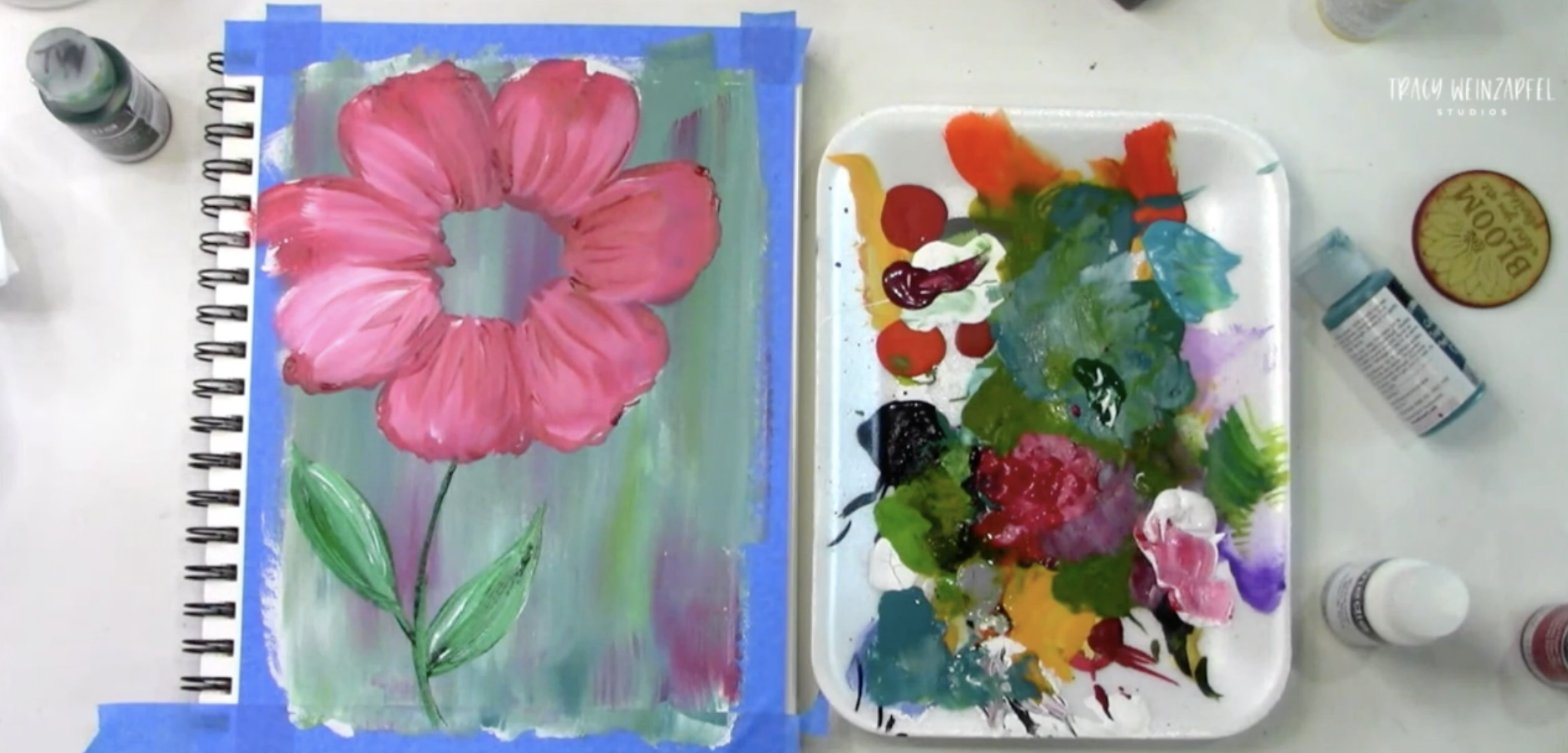 painting a pink flower in an art journal